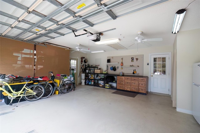 garage featuring ceiling fan, a garage door opener, and white fridge