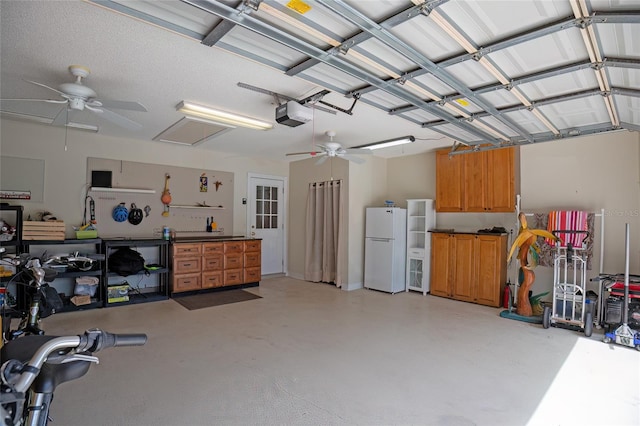 garage featuring a garage door opener, a workshop area, ceiling fan, and white fridge