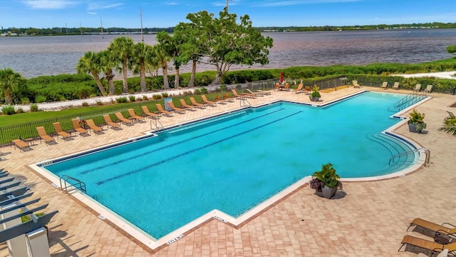 view of swimming pool with a water view and a patio area