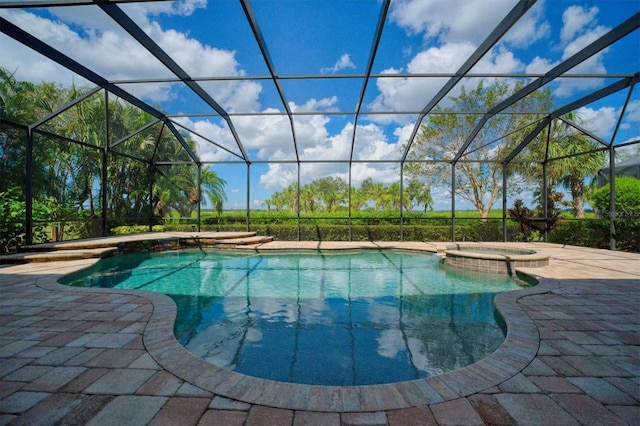 view of swimming pool with an in ground hot tub, glass enclosure, and a patio area