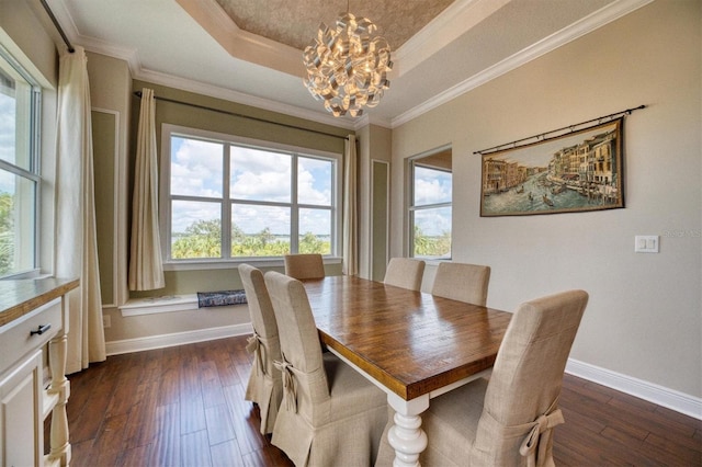 dining space featuring ornamental molding, a raised ceiling, dark hardwood / wood-style floors, and an inviting chandelier