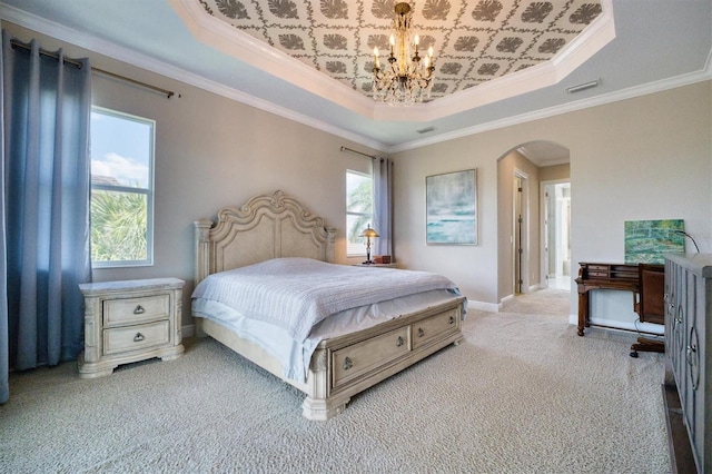 carpeted bedroom featuring ornamental molding, a raised ceiling, and an inviting chandelier