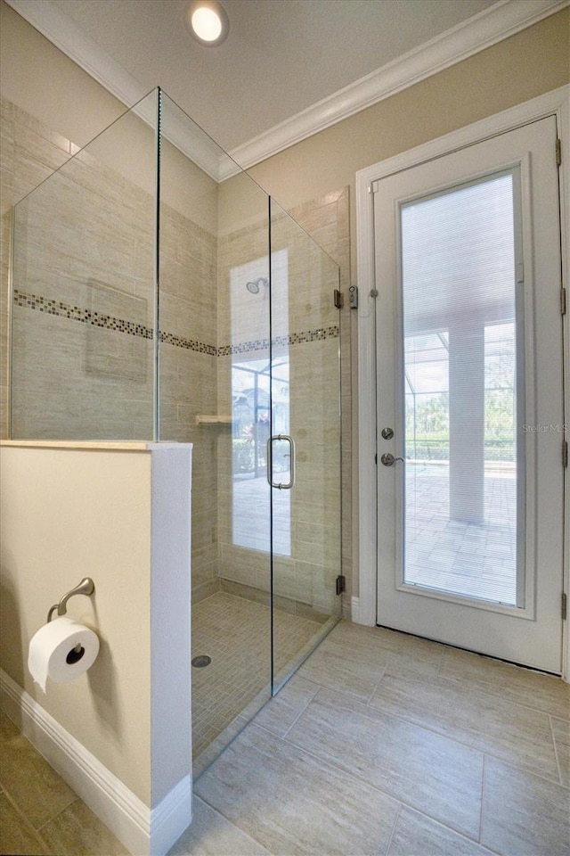 bathroom featuring a shower with shower door and ornamental molding