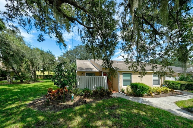 view of front of home featuring a front yard, stucco siding, and fence