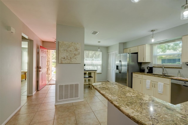 kitchen with pendant lighting, appliances with stainless steel finishes, a healthy amount of sunlight, and sink