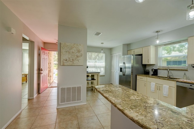 kitchen featuring visible vents, light tile patterned floors, a sink, light stone countertops, and stainless steel appliances