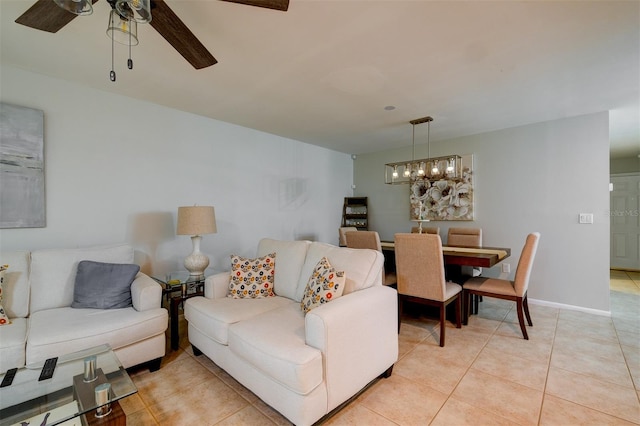 living room with light tile patterned floors, ceiling fan, and baseboards