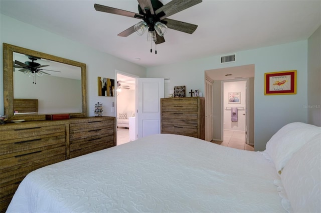 tiled bedroom featuring ensuite bath, a ceiling fan, and visible vents