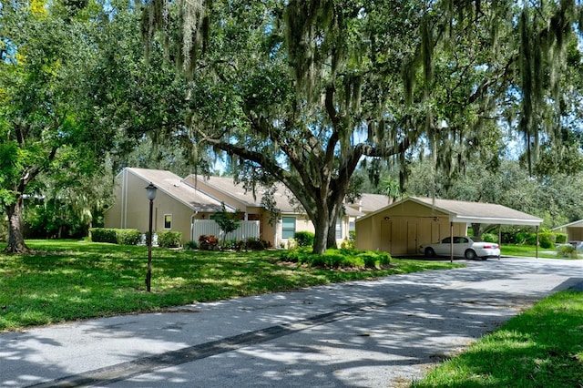 view of side of property featuring a carport, a yard, and driveway