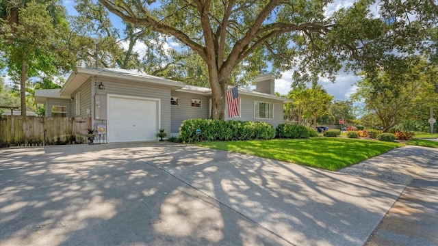 ranch-style home with a front yard, fence, a garage, and concrete driveway