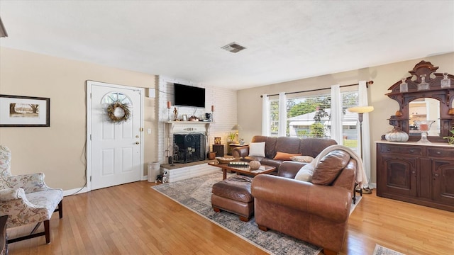 living room with light hardwood / wood-style floors and a fireplace