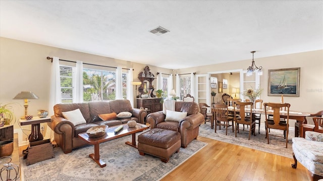 living room featuring a notable chandelier and light wood-type flooring