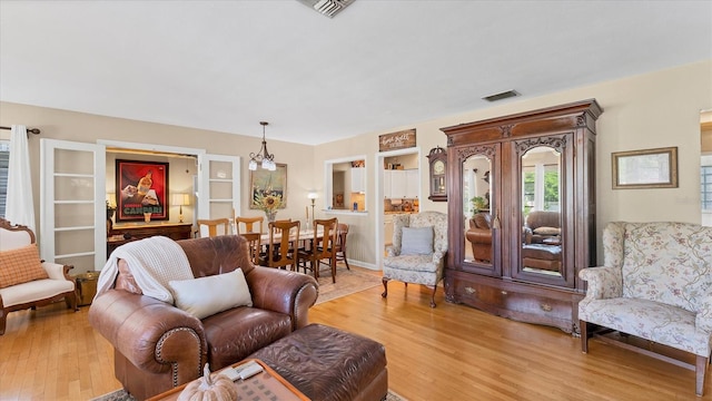 living room with visible vents and light wood-style flooring