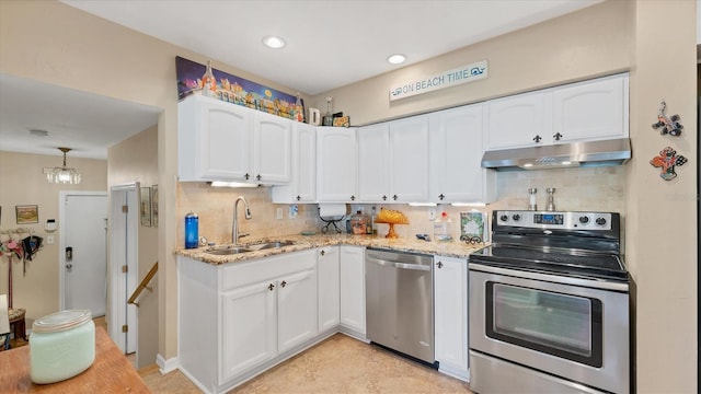 kitchen with light stone counters, white cabinets, under cabinet range hood, appliances with stainless steel finishes, and a sink