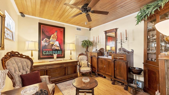 sitting room with light hardwood / wood-style floors, wood ceiling, ornamental molding, and ceiling fan