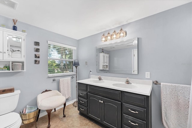 full bathroom featuring toilet, double vanity, a sink, and visible vents