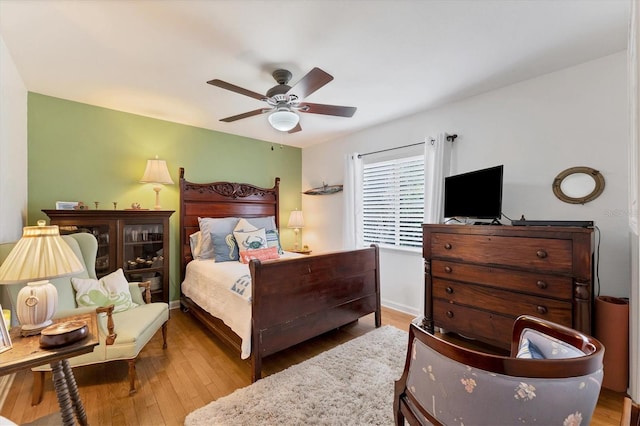 bedroom with ceiling fan and hardwood / wood-style flooring