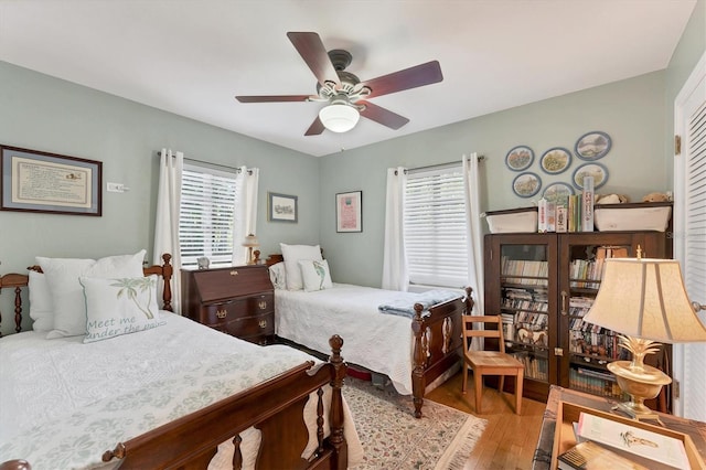 bedroom featuring light hardwood / wood-style flooring, multiple windows, and ceiling fan