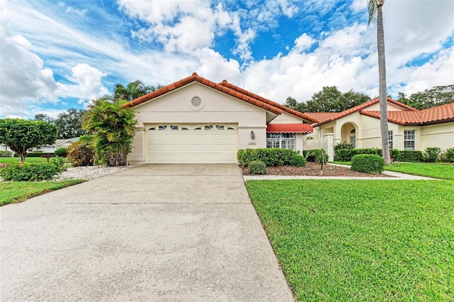 mediterranean / spanish-style house featuring a front yard and a garage