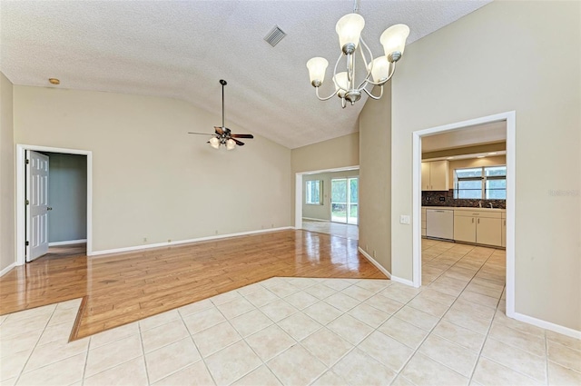 spare room with ceiling fan with notable chandelier, a textured ceiling, light hardwood / wood-style flooring, and plenty of natural light