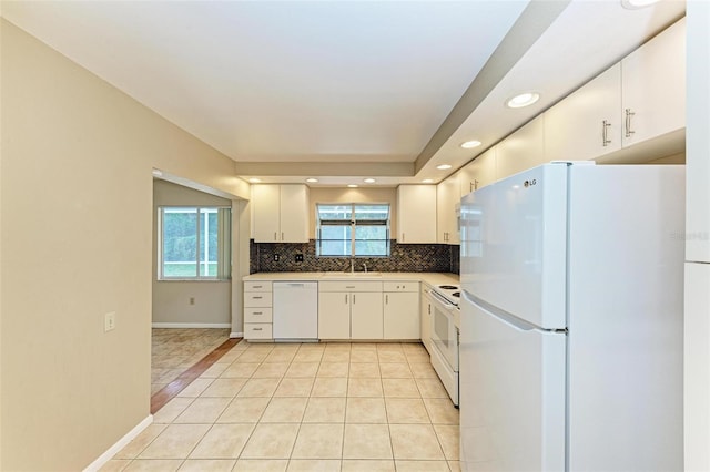 kitchen featuring sink, light tile patterned floors, white appliances, white cabinetry, and decorative backsplash