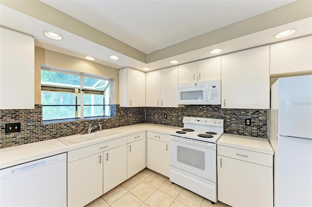 kitchen with white cabinets, light tile patterned flooring, sink, white appliances, and backsplash