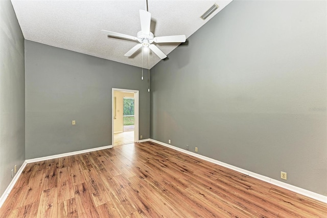 spare room featuring light wood-type flooring, a textured ceiling, ceiling fan, and high vaulted ceiling