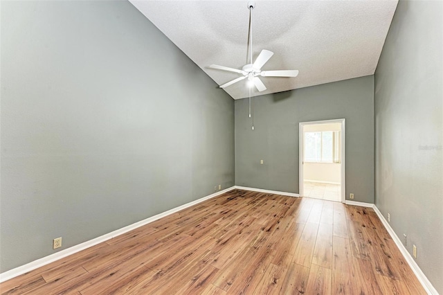 spare room featuring ceiling fan, a textured ceiling, lofted ceiling, and light hardwood / wood-style floors