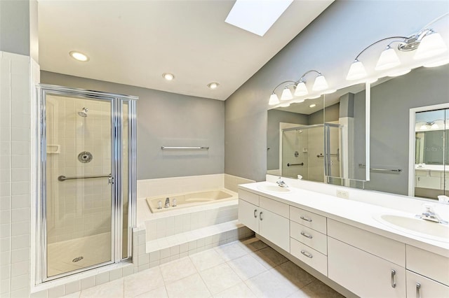 bathroom featuring vanity, a skylight, shower with separate bathtub, and tile patterned flooring