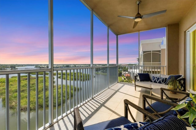 sunroom / solarium featuring a water view and ceiling fan