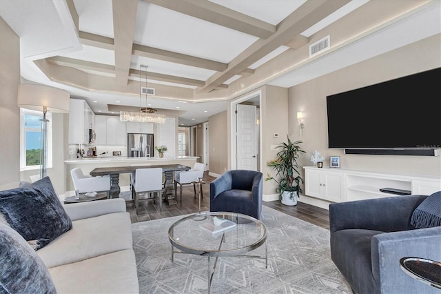 living room featuring coffered ceiling, visible vents, and wood finished floors