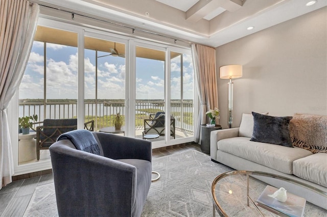 living area featuring a water view, a wealth of natural light, and wood finished floors