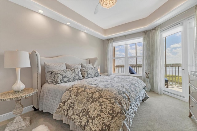 carpeted bedroom with a water view, access to outside, and ceiling fan