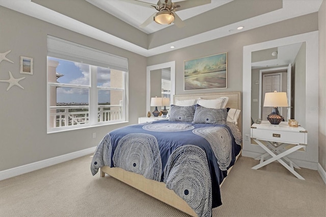 carpeted bedroom featuring a tray ceiling, baseboards, a ceiling fan, and recessed lighting