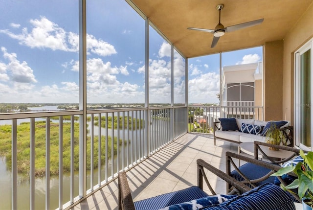 sunroom featuring a water view and ceiling fan