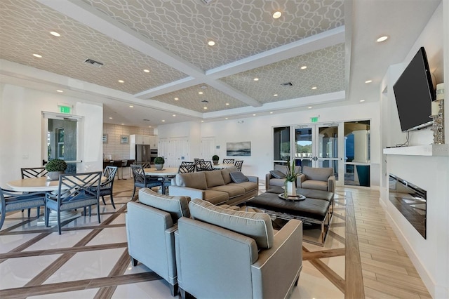 living room featuring beamed ceiling, coffered ceiling, and light hardwood / wood-style flooring