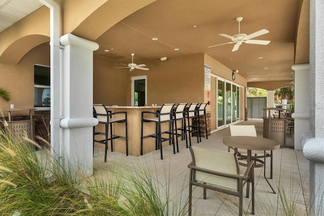 view of patio featuring outdoor dry bar and ceiling fan