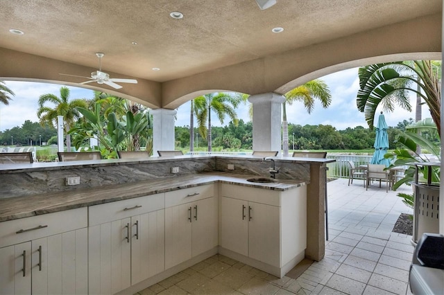 view of patio featuring an outdoor wet bar and ceiling fan