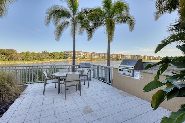 view of patio featuring an outdoor kitchen, a water view, and area for grilling