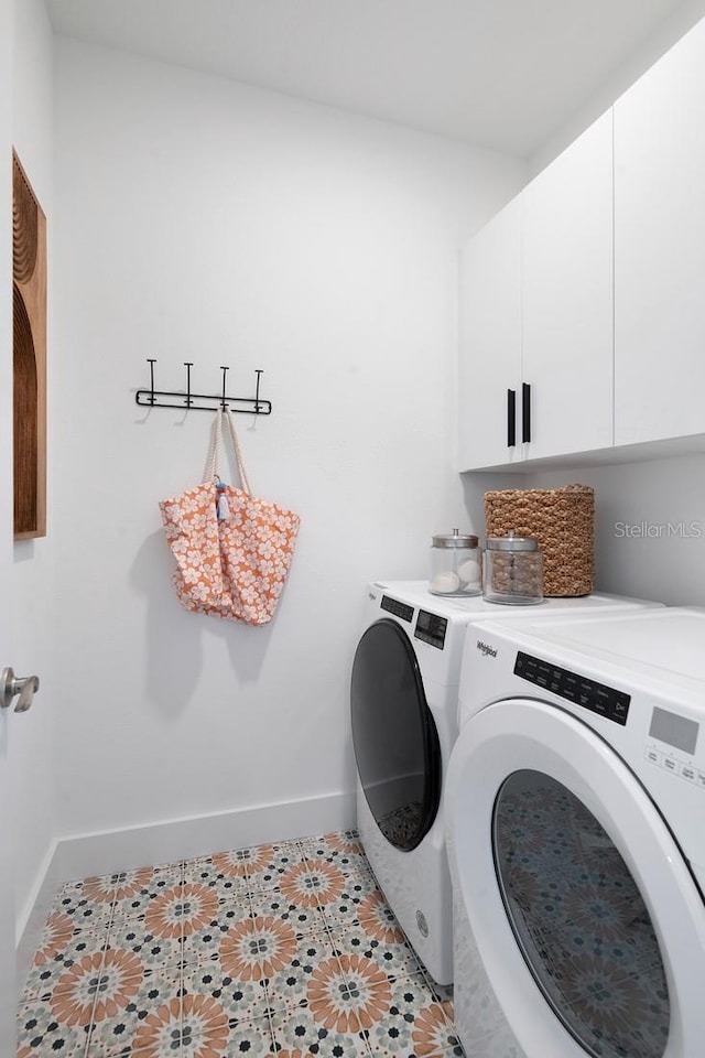 clothes washing area with light tile patterned floors, cabinets, and washer and dryer