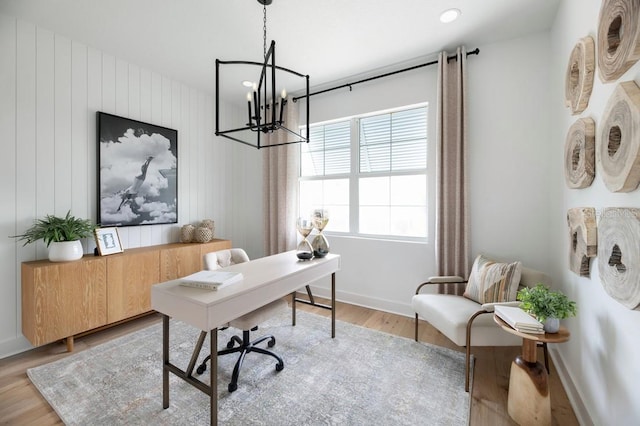 home office with light hardwood / wood-style floors and a chandelier