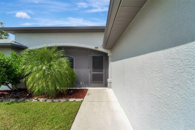 view of exterior entry with a yard