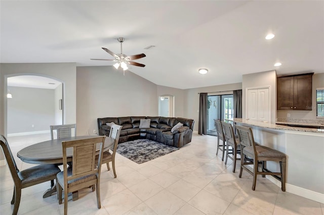 dining room with light tile patterned floors, vaulted ceiling, and ceiling fan