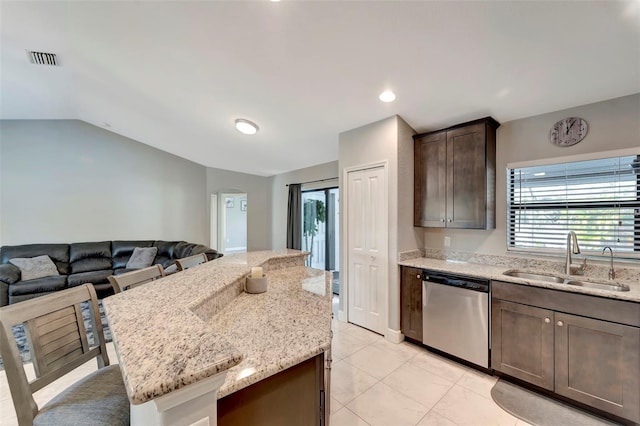 kitchen with dishwasher, a center island, sink, light stone counters, and vaulted ceiling