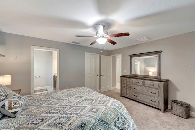 bedroom with ceiling fan, light colored carpet, and ensuite bathroom