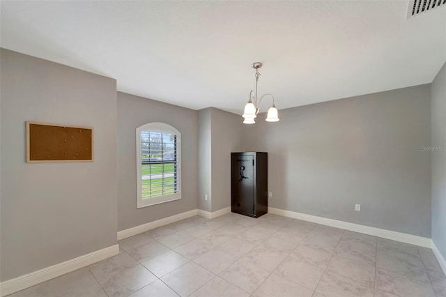 spare room with light tile patterned floors and an inviting chandelier