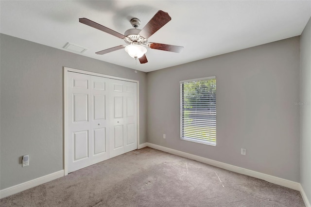 unfurnished bedroom with carpet flooring, ceiling fan, and a closet