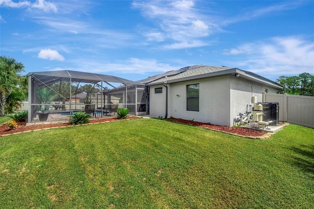 back of house with a lawn, a lanai, and a pool