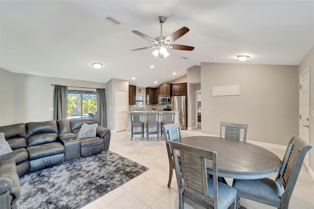 tiled living room featuring ceiling fan and vaulted ceiling