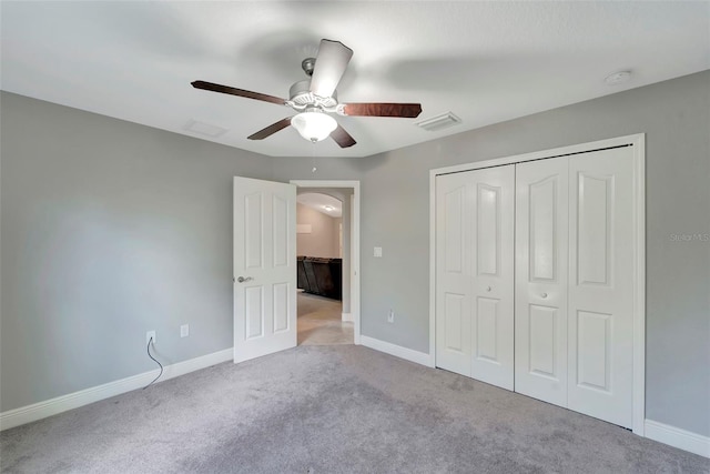 unfurnished bedroom featuring ceiling fan, a closet, and light carpet